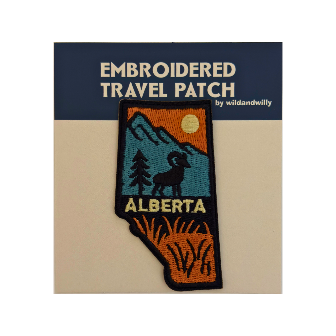 Embroidered travel patch of Alberta on a card with 'wildandwilly' branding.